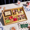 Assorted sympathy dessert box with a card on a marble table.