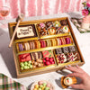 An Easter dessert board filled with macarons, chocolates, a 'Happy Easter' cookie, and bunny and carrot themed treats, served with a chocolate mallet.