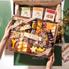 New Year's charcuterie board with assorted cheeses, cured meats, nuts, olives, and Boarderie branded cracker boxes.