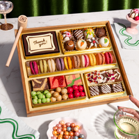 Dessert gift box featuring two rows of colorful macarons, decorated chocolate truffles, a 