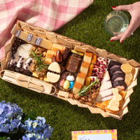 Easter themed cheese board with gourmet cheeses, fig jam, nuts, dried fruits, candy eggs, and festive bunny and egg-shaped cheese.
