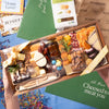 Easter charcuterie board with assorted cheeses, nuts, dried fruits, fig jam, and a festive egg-shaped cheese cutout.