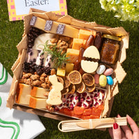 Charcuterie for Easter featuring cheeses, dried fruits, nuts, fig jam, candy eggs, and festive bunny and egg-shaped cheese cutouts.