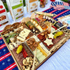 Festive 4th of July charcuterie board with assorted cheeses, meats, nuts, crackers, & star-shaped cheese slices