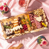 Charcuterie board for Mother’s Day with meats, cheeses, nuts, dried fruits, and cheese cutouts shaped like “MOM” and a heart.