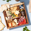 Passover charcuterie board with matzo, dried fruits, nuts, herb-garnished cheeses, fig jam, and star and bow-shaped cheese accents.