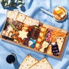 Medium Passover cheese board featuring matzo, a Star of David cheese cutout, artisan cheeses, candied walnuts, dates, fig jam, dried fruit, and blue and white candies on a blue linen backdrop
