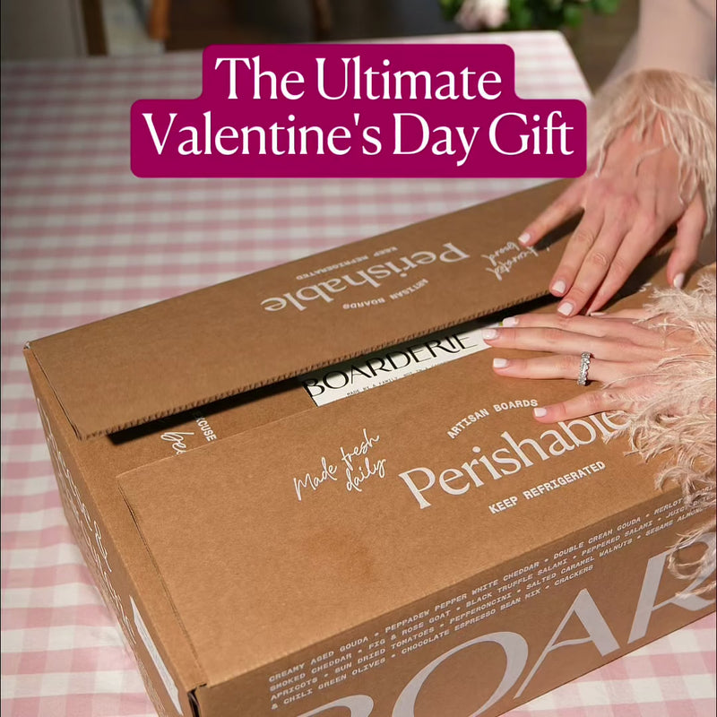 Valentine cheese board gift box being opened, labeled perishable and made fresh daily, perfect for a romantic celebration.
