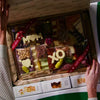 charcuterie board gift unboxing of Mothers Day cheese and meat board. Box opens and fully-arranged board is taken out and enjoyed. Family clink glasses over board. Ends with a grazing table of Mother's Day boards in every size.