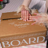 Valentine’s charcuterie gift box from Boarderie, wrapped in branded packaging with crackers and a romantic green and pink presentation.