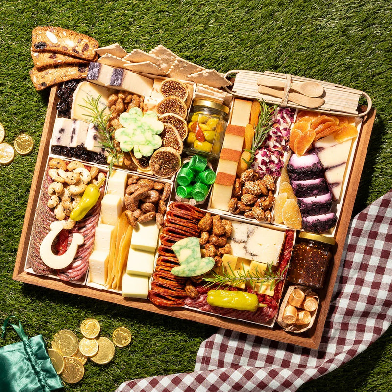 St. Patrick’s charcuterie board with gourmet cheeses, cured meats, figs, nuts, and festive cheese cutouts shaped like a shamrock, horseshoe, and leprechaun hat.