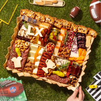 Super Bowl charcuterie board with gourmet cheeses, meats, nuts, and cheese cutouts shaped like a helmet, jersey, and “LX.”