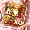 Valentine’s Day cheese board with artisan cheeses, cured meats, nuts, olives, and romantic cheese cutouts shaped like a heart and XO.