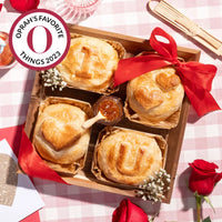 Wooden tray with baked brie pastries spelling 